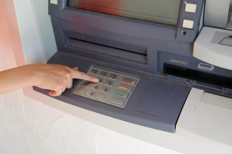 Hand of girl type the secret code in the ATM's keyboard to pick up the money Stock Photos