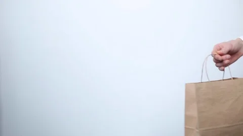 Hand gives paper empty packaging to another hand. Eco concept. Shopping Stock Footage 119233007