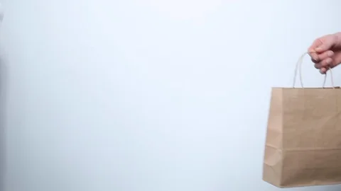 Hand gives paper empty packaging to another hand. Eco concept. Shopping Stock Footage 119233540