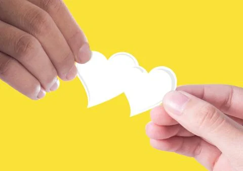 Hand giving a white heart to hand Stock Photos