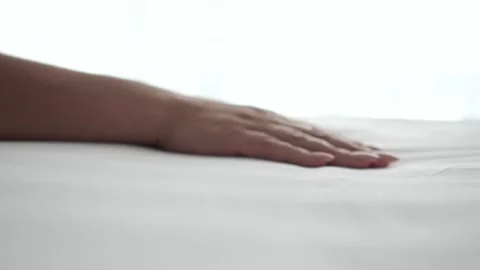 Hand glides neatly pressed bedsheet appreciating perfect texture Video stock 301384208