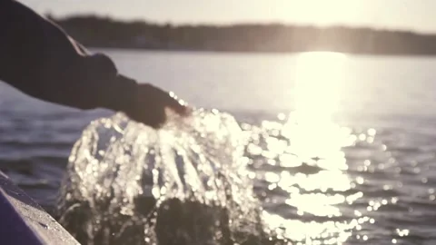 Hand glides over waves at sunset Stock Footage 261538408