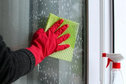 Hand in glove cleans window Stock Photos
