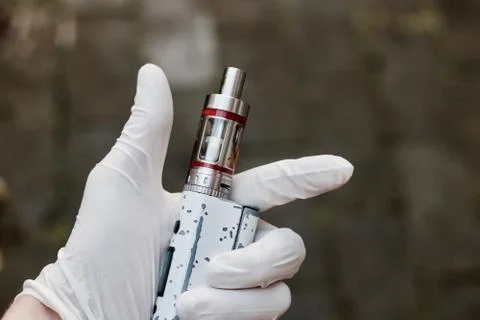 Hand in glove with electronic cigarette Stock Photos