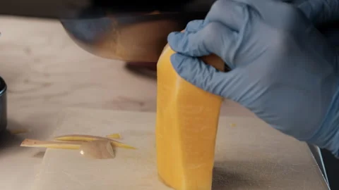 Hand in glove peeling pumpkin on cutting board Stock Footage 343550802