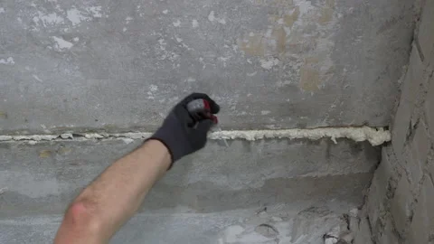 Hand in glove removing foam from ceiling Stock Footage 156913577