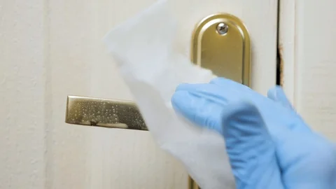 Hand in glove sanitizing door knob. Disinfecting from viruses and bacterium Stock Footage 128153232
