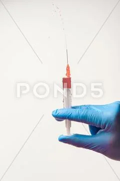 Hand In Glove With Syringe On White Background.