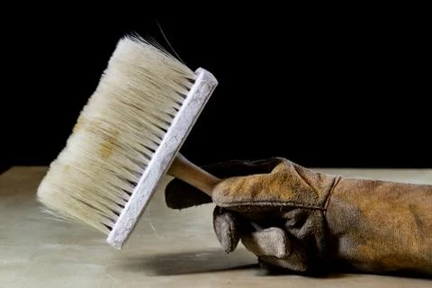 Hand in glove with tool for work in workshop. Hand protected by working coat. Stock Photos