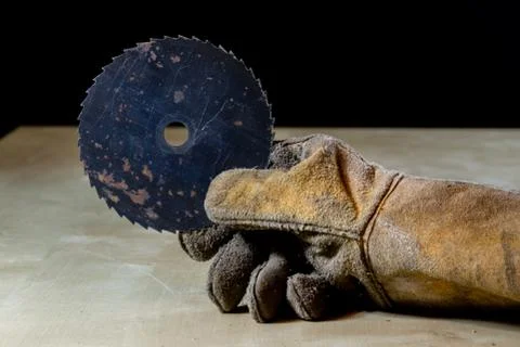 Hand in glove with tool for work in workshop. Hand protected by working coat. Stock Photos