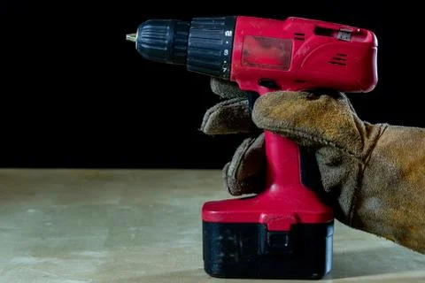 Hand in glove with tool for work in workshop. Hand protected by working coat. Stock Photos