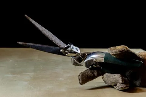 Hand in glove with tool for work in workshop. Hand protected by working coat. Stock Photos