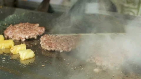 Hand with glove using flipper flipping meat pork with smoke on hot griddle pan. Stock Footage 201399523