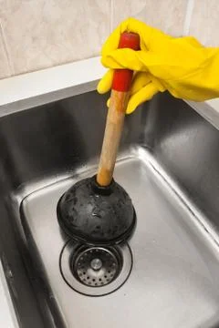 Hand in glove using a plunger Stock Photos