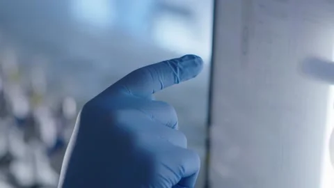 Hand with gloves touching a computer screen, programming a medicines production Stock Footage 153476164