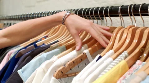 Hand goes through clothes rack Video stock 66903217