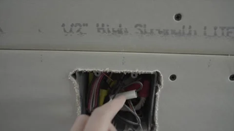 Hand goes through exposed wires outlet Stock Footage 301104513