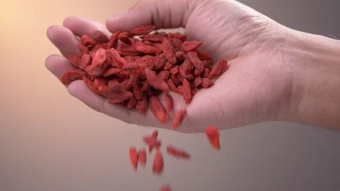 Hand with goji berries falling in slow motion Stockbeeldmateriaal 137088091