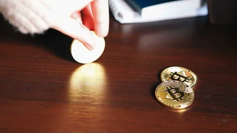 Hand with gold bitcoin at workplace, cryptocurrency concept Stock Footage 85607693