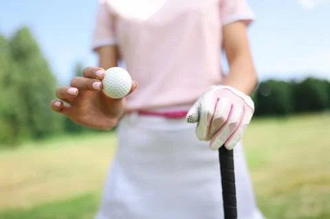 In hand of golf ball second gloved hand holds golf club. 스톡 사진