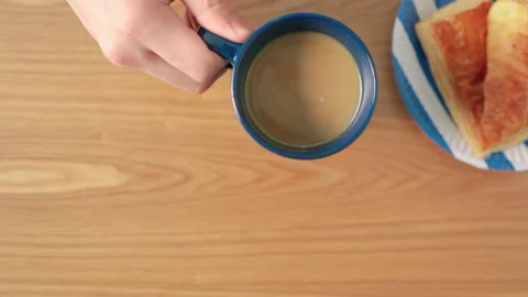 Hand grab cup of coffee on table with bread breakfast Vídeos de archivo 158379014