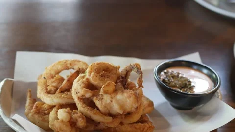 Hand grab a piece of deep fried calamari crispy fresh squid dipped in tarta.. Stock Footage 277354343