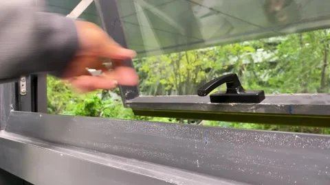 Hand grab window handle turn to open and turn to lock close window at office. Stock Footage 249664187