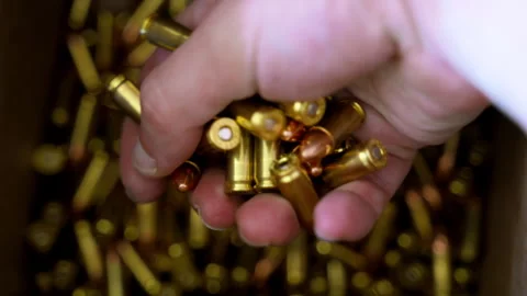 Hand grabbing bullets from the box with ammunition. Close up of person sorting Stock Footage 334021308