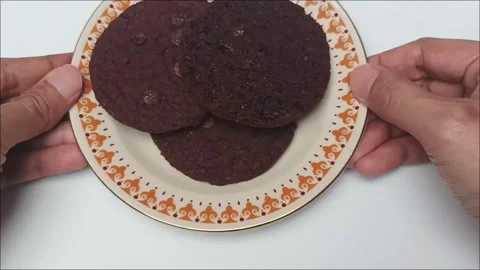 Hand Grabbing Dark Chocolate Cookie from Vintage Plate Video stock 342236817