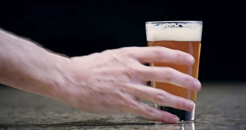 Hand grabbing a pint of beer and pulling it off bar 4k Stock Footage