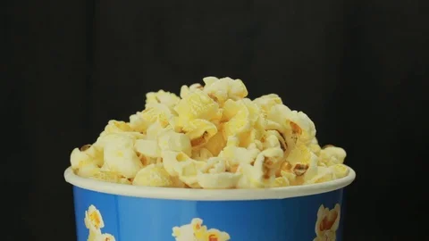 Hand grabbing popcorn on black background Stock-Footage 70948422