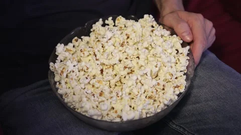 Hand grabbing popcorn from a bowl while watching TV Stock Footage 159666571