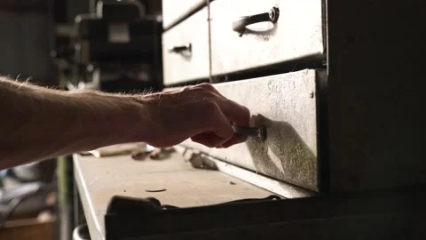 A hand grabbing a tool out of an old toolbox located in an old barn. Shot Stock Footage 162950398