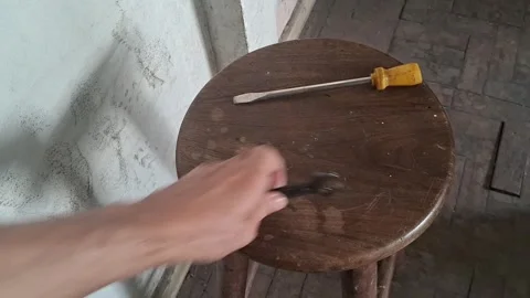Hand grabbing tools from a rustic wooden stool video motion Stock Footage 337844143