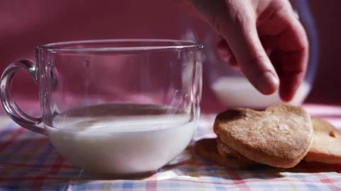 Hand grabs fresh baked cookie with glass of milk Stock Footage 169857598