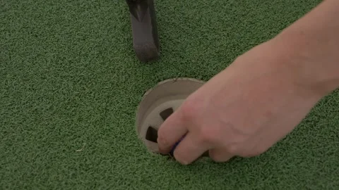 Hand grabs golf ball out of hole Stock Footage 272804837