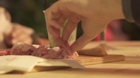 A hand grabs ham from a chopping board Stock Footage 82029379