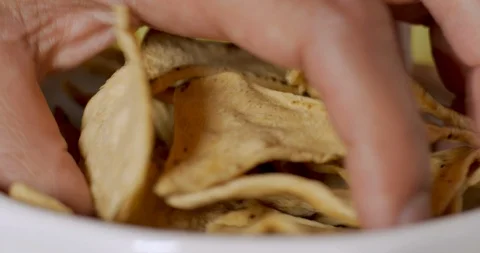 Hand grabs a handful of corn tortilla chips from a bowl Video stock 92736228