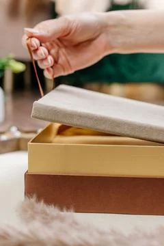 Hand gracefully opens a stylish and beautifully designed gift box that show.. Stock Photos