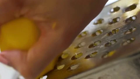 Hand grates a fresh yellow potato on metal grater Vídeos de archivo 333831445