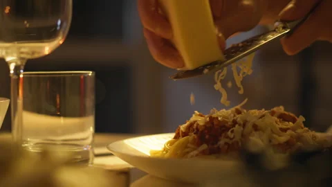 Hand grating cheese over a plate of pasta during an intimate dinner at home Vídeo Stock 295125343