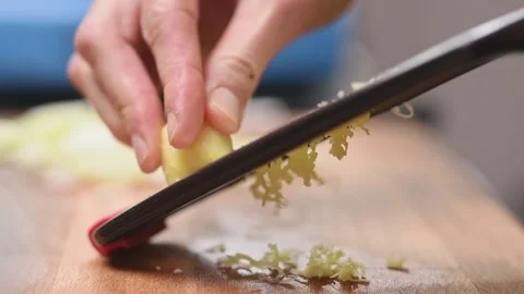 Hand grating a fresh ginger, slow motion. Stock Footage 154328445