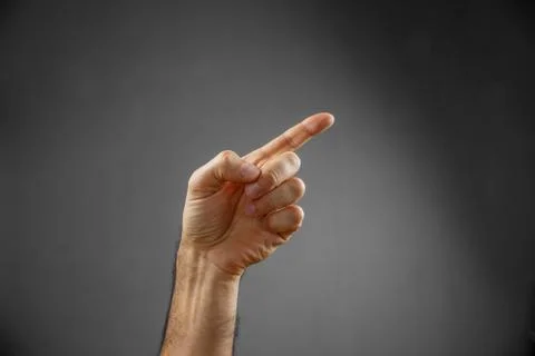 Hand on a gray background. pointing gesture Stock Photos