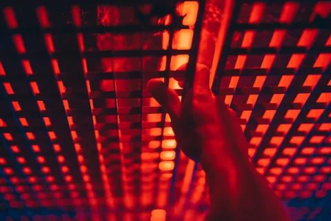 Hand on a grid, red light, man hand Stock Photos