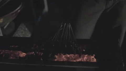 A hand grilling satay at night Stock Footage 227462643