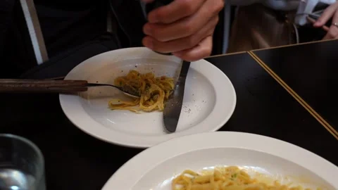 A hand grinds black pepper above creamy pasta Video stock 335112172