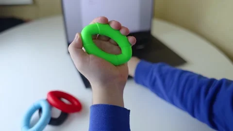 Hand gripper. Man squeezes rubber expander while working on his laptop. Concept  Stock Footage 265652906