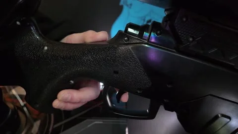 Hand gripping black tactical firearm trigger in low light environment Vídeo Stock 343682448