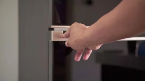 Hand gripping fridge door handle and opening it. Kitchen routine and appliance Stock Footage 342636033