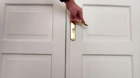 Hand Gripping Gold Handle While Closing White Double Door Indoors Vídeos de archivo 328285740